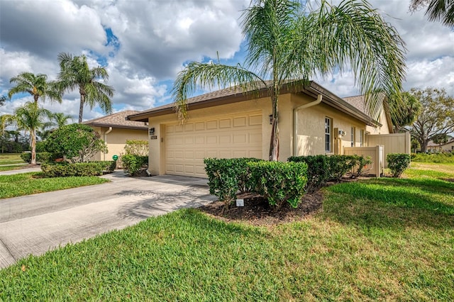 view of side of home with an attached garage, a yard, driveway, and stucco siding