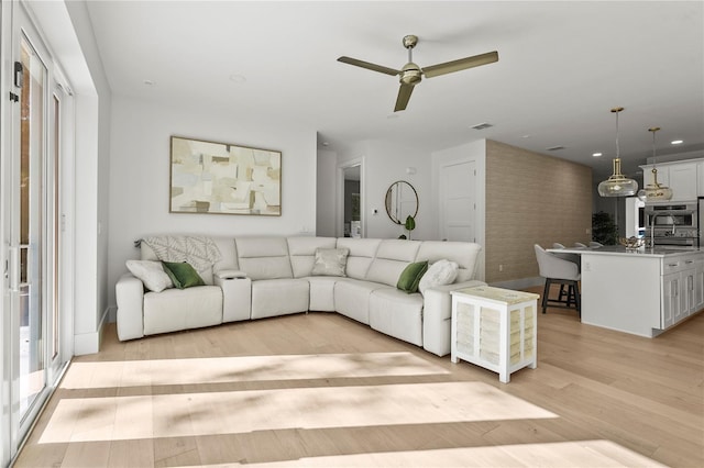 living room featuring recessed lighting, light wood-type flooring, and a ceiling fan