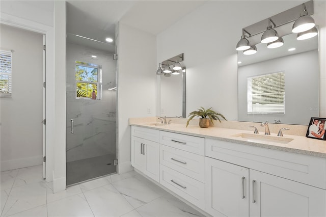 full bath with a marble finish shower, marble finish floor, double vanity, and a sink