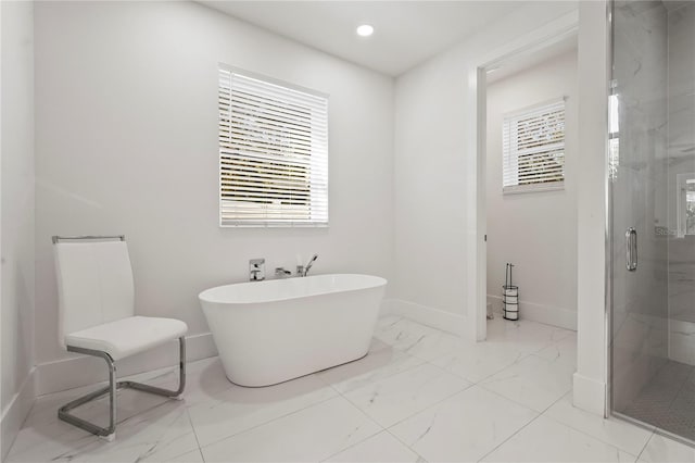 full bathroom featuring a marble finish shower, plenty of natural light, marble finish floor, and a freestanding bath