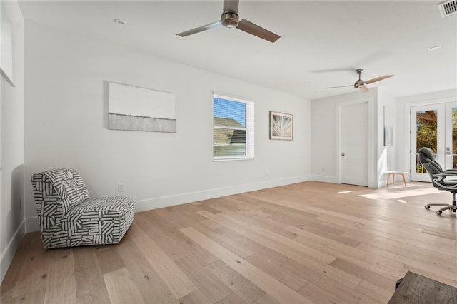 sitting room with french doors, baseboards, and light wood finished floors