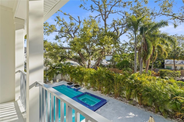 exterior space featuring fence and a pool with connected hot tub