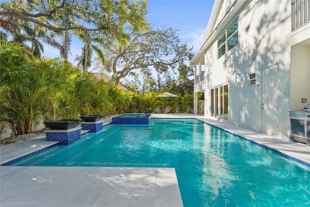 view of swimming pool with a pool with connected hot tub and a patio