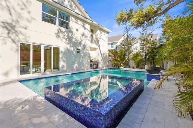 view of pool featuring a patio area and a pool with connected hot tub