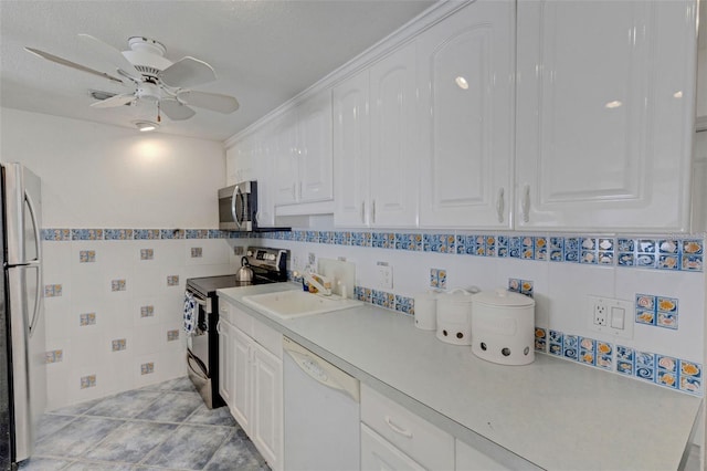 kitchen with white cabinetry, sink, tile walls, ceiling fan, and appliances with stainless steel finishes