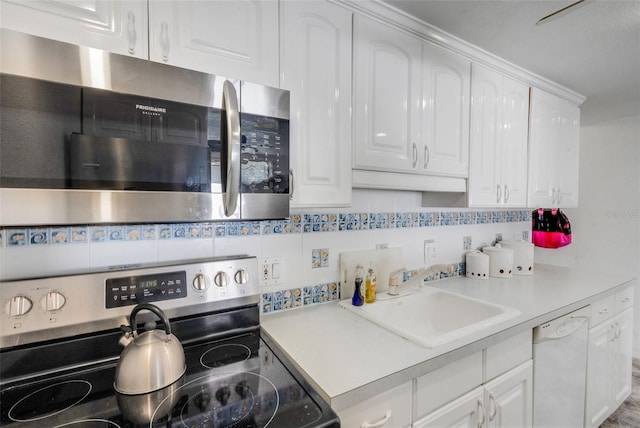 kitchen with white cabinetry, appliances with stainless steel finishes, sink, and decorative backsplash