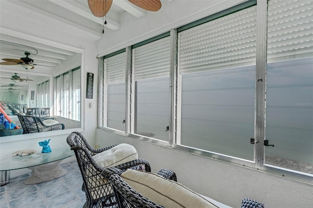 sunroom / solarium with ceiling fan and beam ceiling