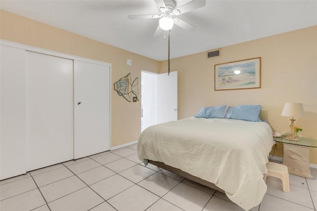 bedroom with ceiling fan, light tile patterned flooring, and a closet