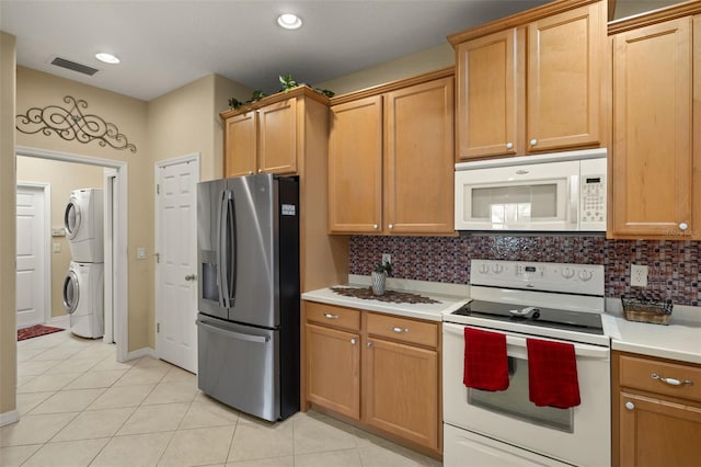 kitchen featuring light countertops, white appliances, stacked washer and clothes dryer, and tasteful backsplash