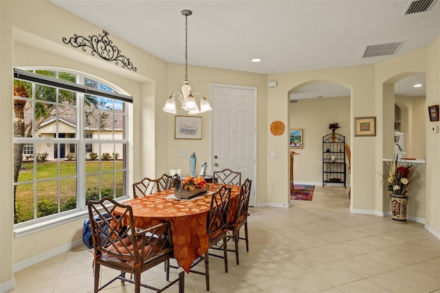 dining space with arched walkways, visible vents, and baseboards