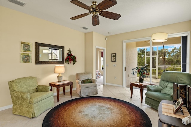 sitting room with ceiling fan, light tile patterned flooring, visible vents, and baseboards