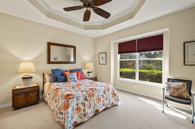 bedroom with a raised ceiling, ornamental molding, light carpet, ceiling fan, and baseboards