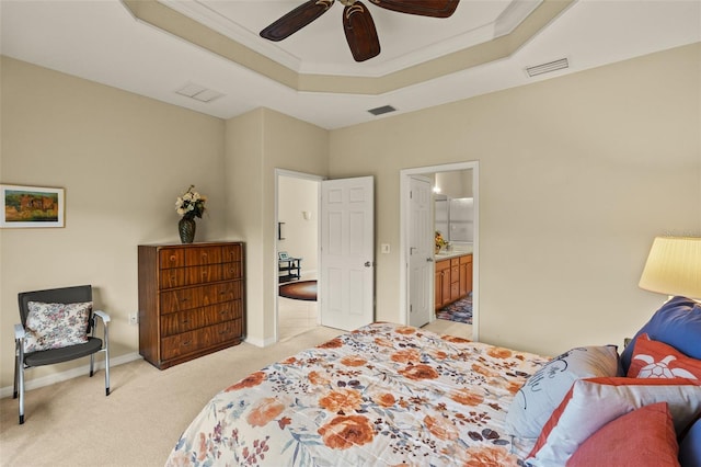 bedroom featuring visible vents, a tray ceiling, light colored carpet, and ornamental molding