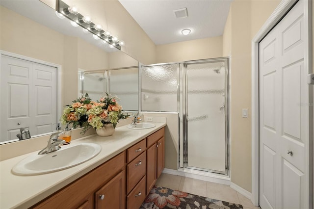 bathroom featuring a stall shower, tile patterned flooring, visible vents, and a sink