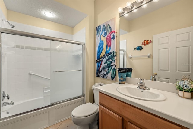 full bath featuring toilet, tile patterned floors, combined bath / shower with glass door, a textured ceiling, and vanity