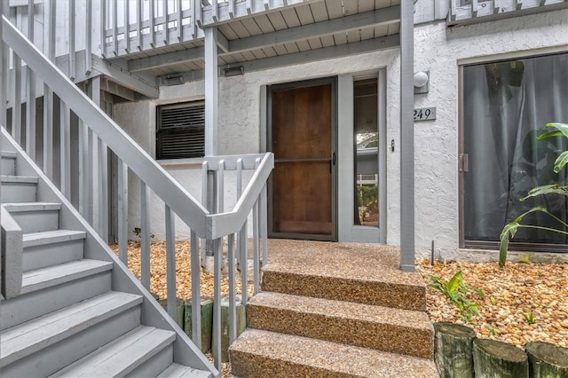 entrance to property featuring stucco siding