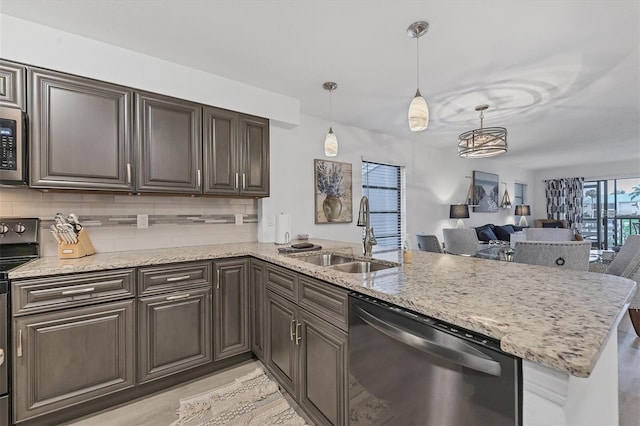 kitchen featuring electric range oven, a peninsula, stainless steel dishwasher, and a sink