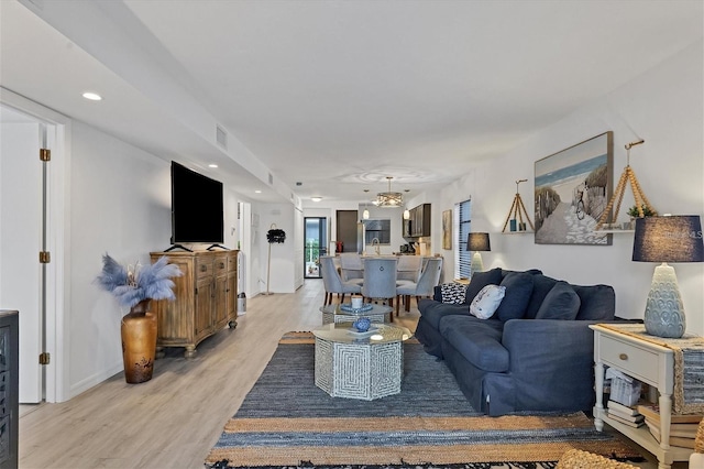 living room featuring baseboards, light wood-style flooring, and recessed lighting