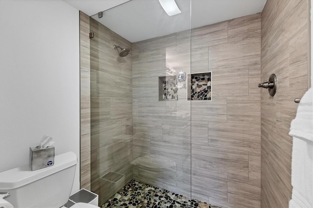 full bath with tiled shower and toilet