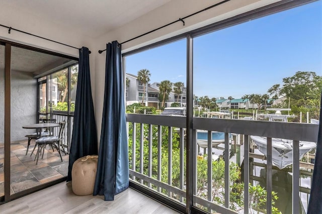 sunroom / solarium with a residential view and a water view