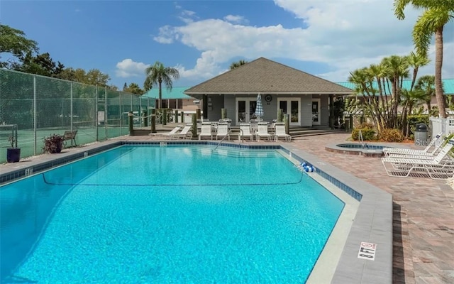 community pool with a community hot tub, french doors, a patio, and fence