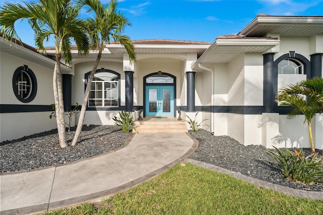 view of exterior entry with stucco siding and french doors