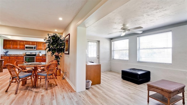 interior space featuring a textured ceiling, ceiling fan, and light hardwood / wood-style floors