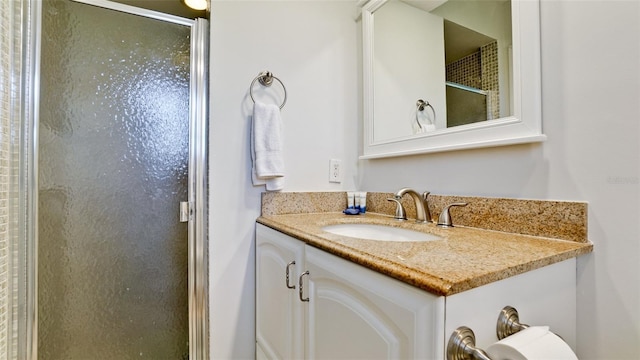 bathroom featuring vanity and a shower with door