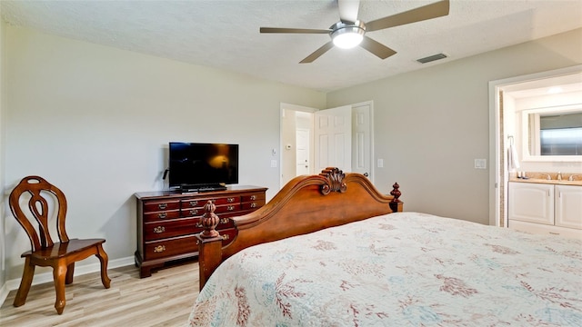 bedroom with ceiling fan, sink, light wood-type flooring, and a textured ceiling