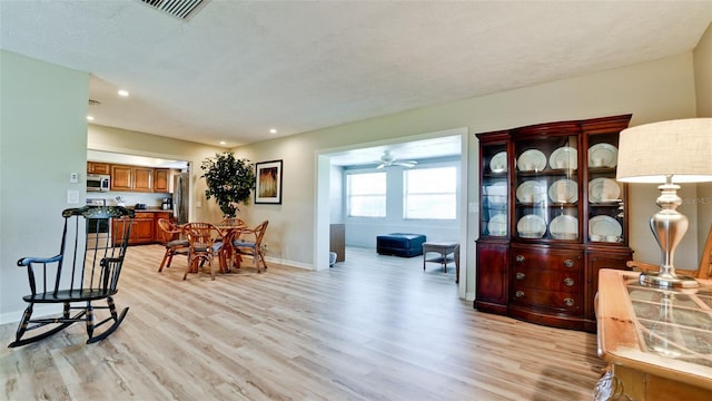 dining space featuring light wood-type flooring and ceiling fan