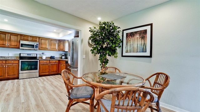 kitchen featuring appliances with stainless steel finishes, light stone countertops, and light hardwood / wood-style floors