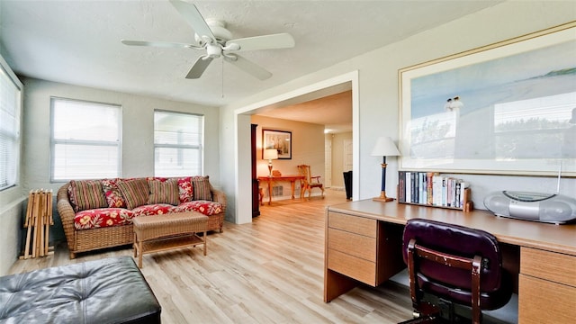 office area with light hardwood / wood-style floors, ceiling fan, and a textured ceiling