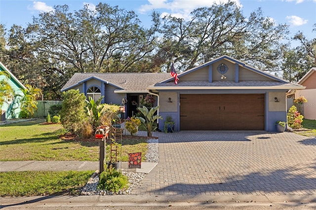 ranch-style home featuring a garage, a front lawn, decorative driveway, and stucco siding