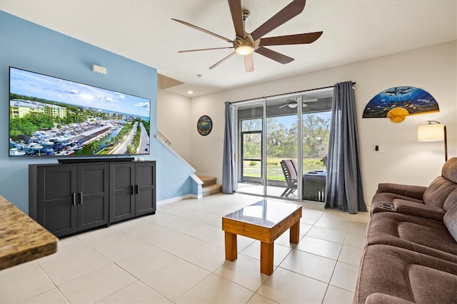 living area featuring stairs, light tile patterned floors, baseboards, and ceiling fan