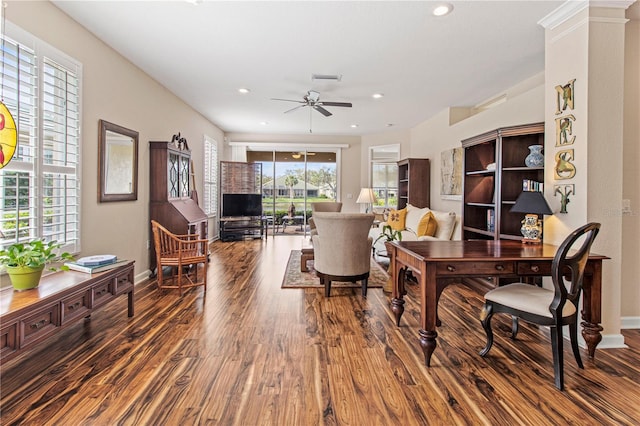 living room featuring baseboards, visible vents, a ceiling fan, and wood finished floors