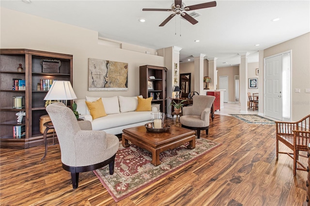 living room with a ceiling fan, wood finished floors, decorative columns, and recessed lighting