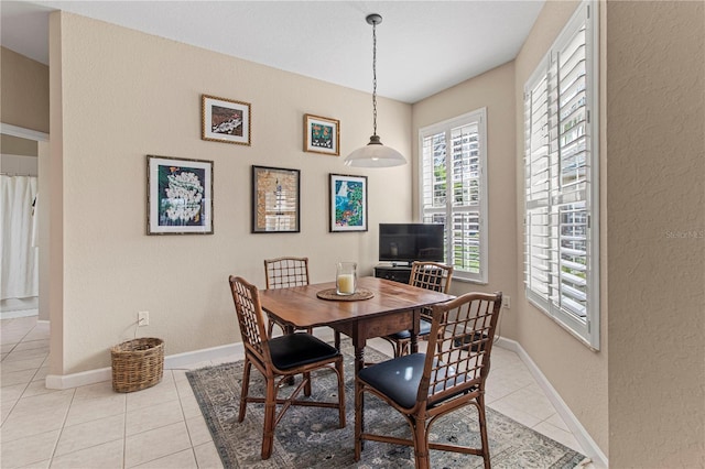 dining space with light tile patterned flooring and baseboards