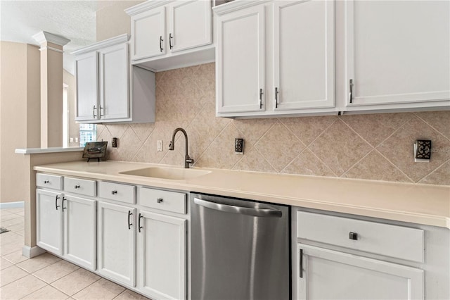 kitchen featuring tasteful backsplash, light countertops, white cabinetry, a sink, and dishwasher