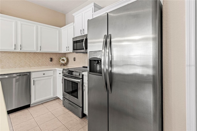 kitchen featuring light tile patterned floors, light countertops, appliances with stainless steel finishes, and white cabinetry