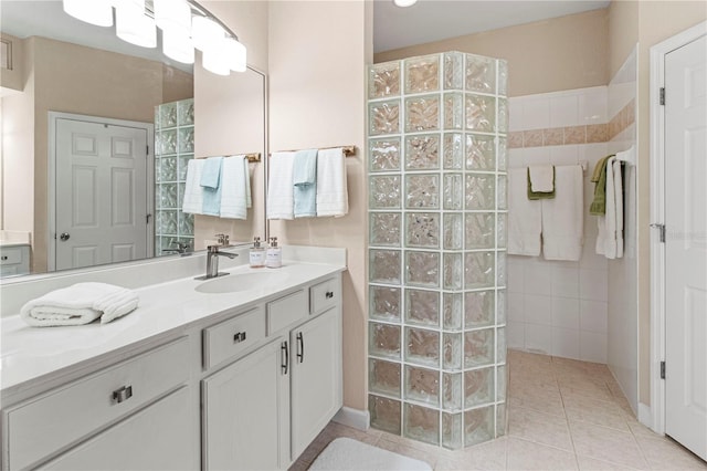 bathroom featuring tile patterned flooring, walk in shower, and vanity