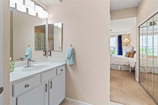 bathroom featuring a textured wall, ensuite bath, vanity, and baseboards