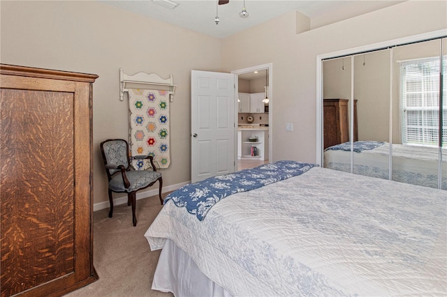 carpeted bedroom featuring a ceiling fan, a closet, and baseboards