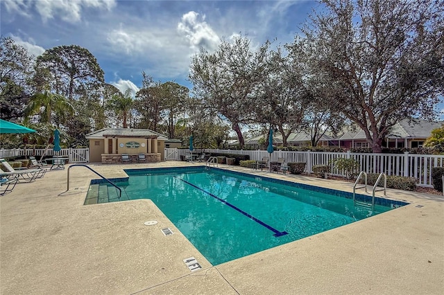 community pool featuring a patio area and fence