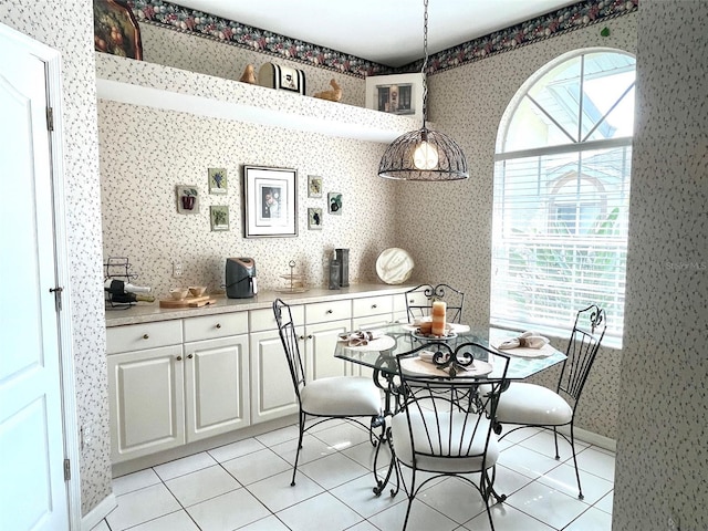 dining area with wallpapered walls, light tile patterned floors, and baseboards