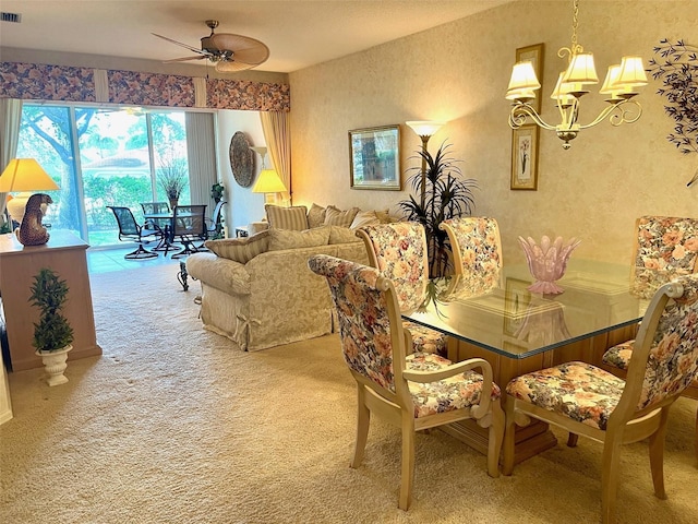 carpeted dining room featuring visible vents and ceiling fan with notable chandelier