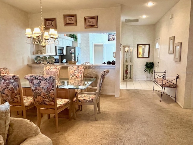 dining area featuring light colored carpet, visible vents, light tile patterned flooring, and an inviting chandelier