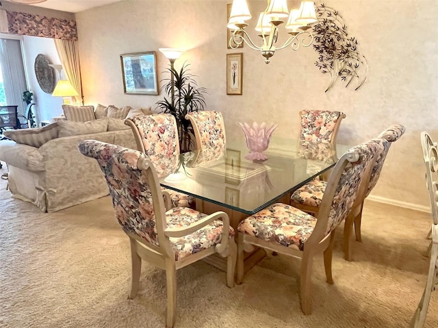 carpeted dining space with baseboards and an inviting chandelier