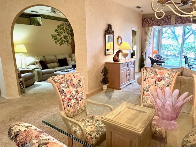 sitting room with baseboards, visible vents, arched walkways, and light colored carpet