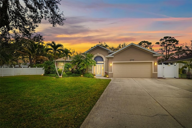 ranch-style house with concrete driveway, a lawn, an attached garage, and stucco siding