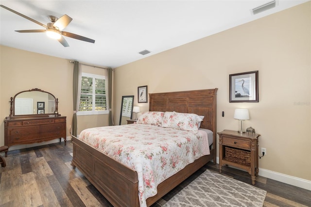 bedroom with baseboards, a ceiling fan, visible vents, and dark wood finished floors